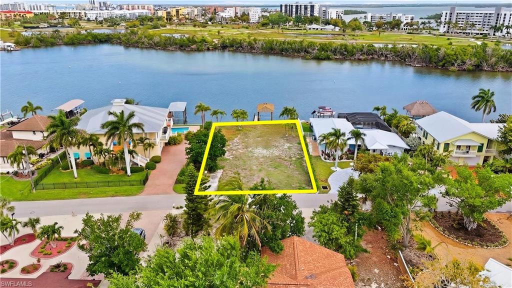 View of urban area featuring property parcel outlined, a large body of water, and nearby suburban area - Virtually Edited Image