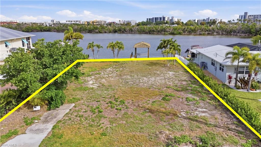 View of urban area with property boundaries highlighted and a nearby body of water - Virtually Edited Image
