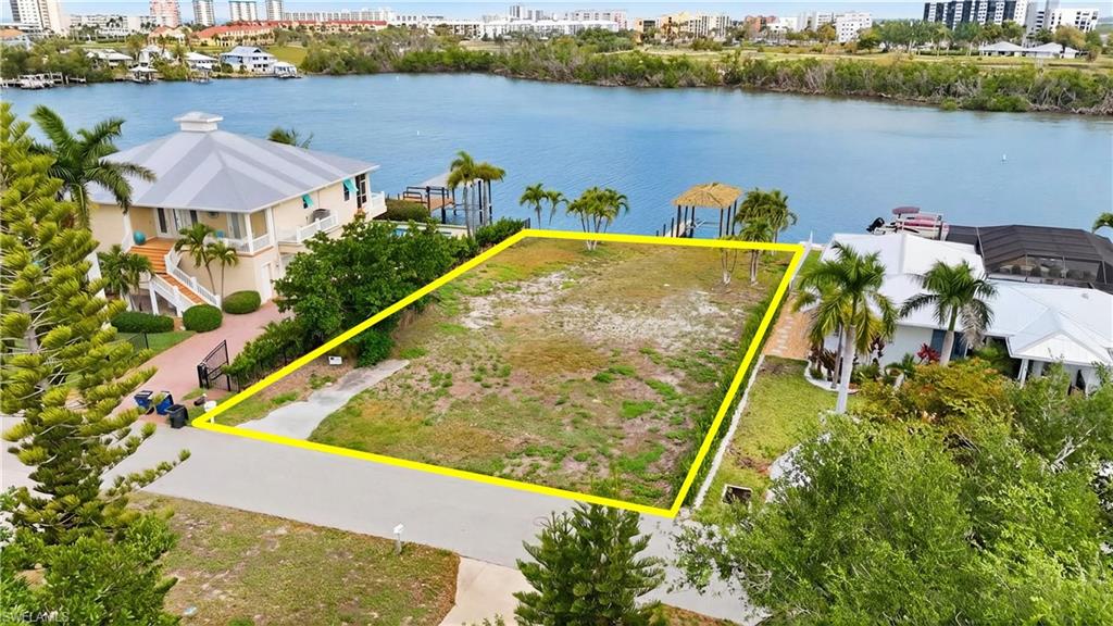 View of urban area with property parcel outlined and a large body of water - Virtually Edited Image