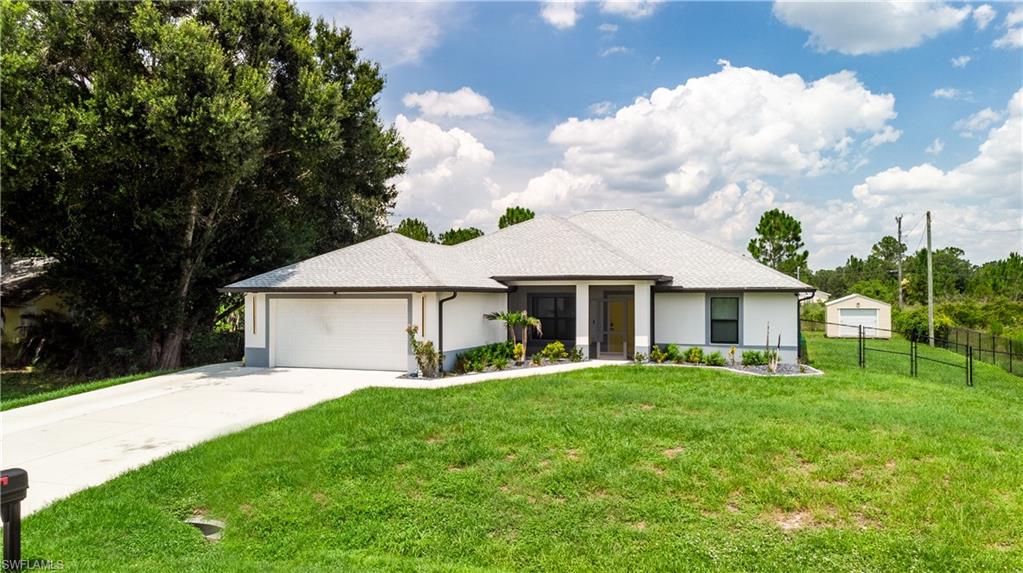 Expansive rear yard featuring a large detached shed, fenced perimeter, and a central fire pit area