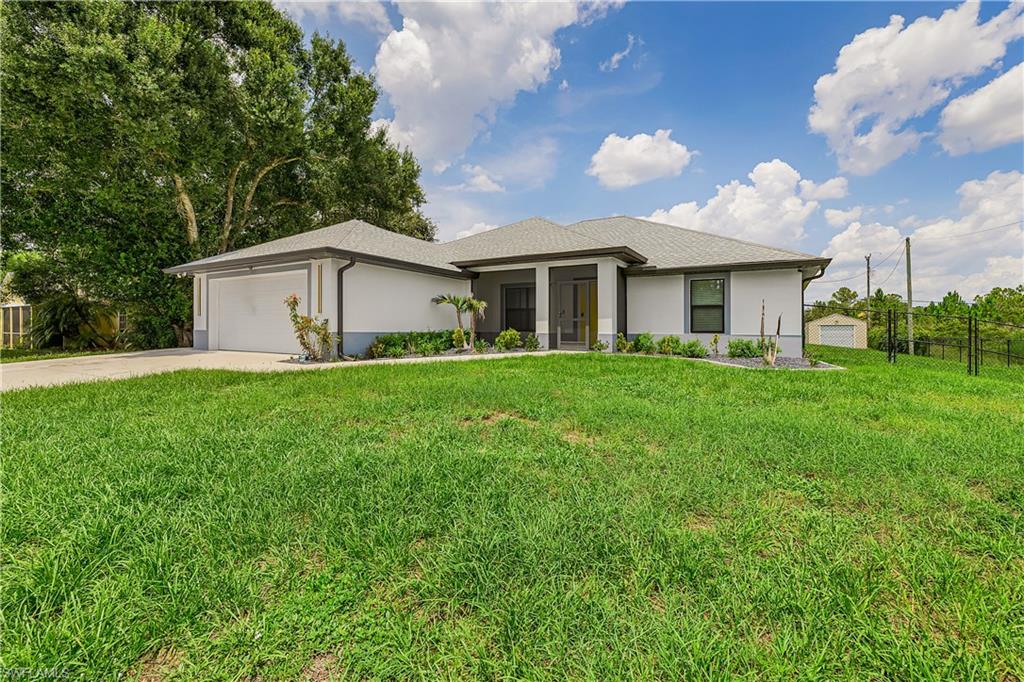 Modern single-story residence featuring a two-car garage, covered entry, and a large front lawn