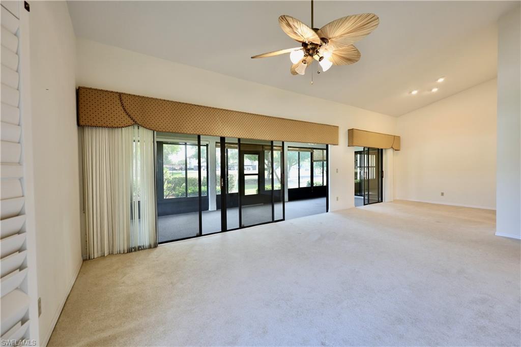 Spare room featuring light colored carpet, a ceiling fan, vaulted ceiling, and recessed lighting