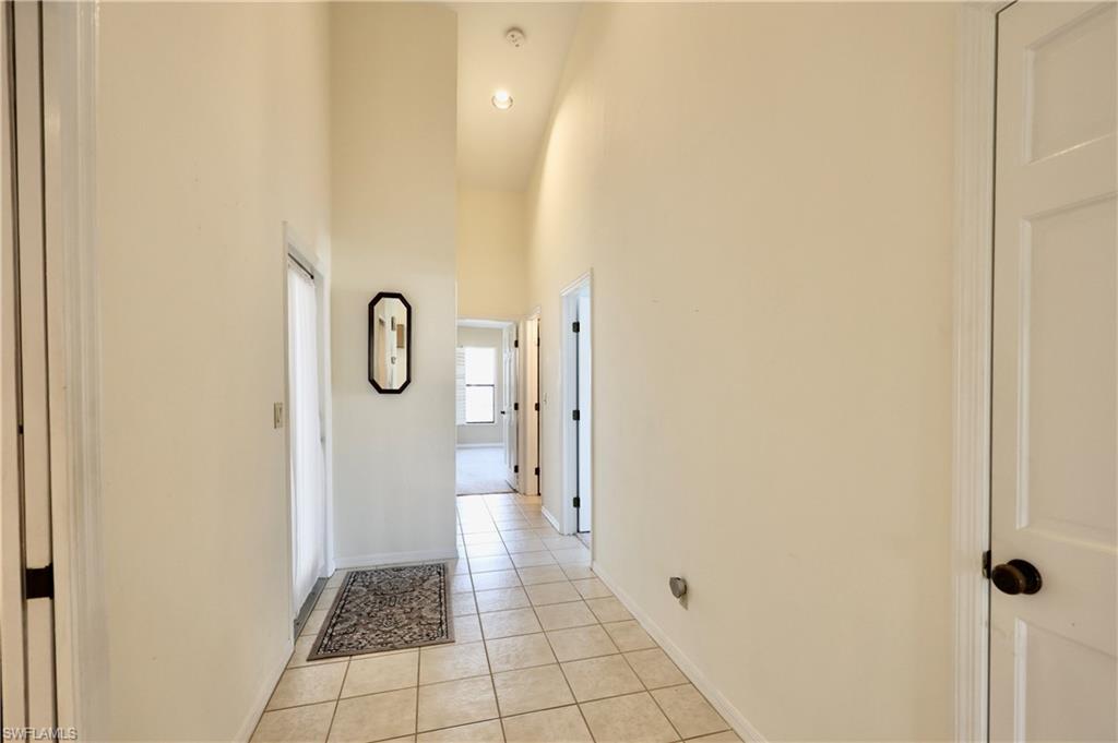 Corridor featuring a high ceiling and light tile patterned floors