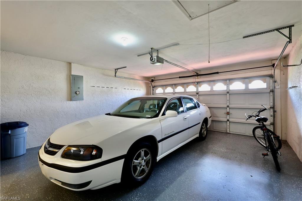 Garage with electric panel and a textured wall