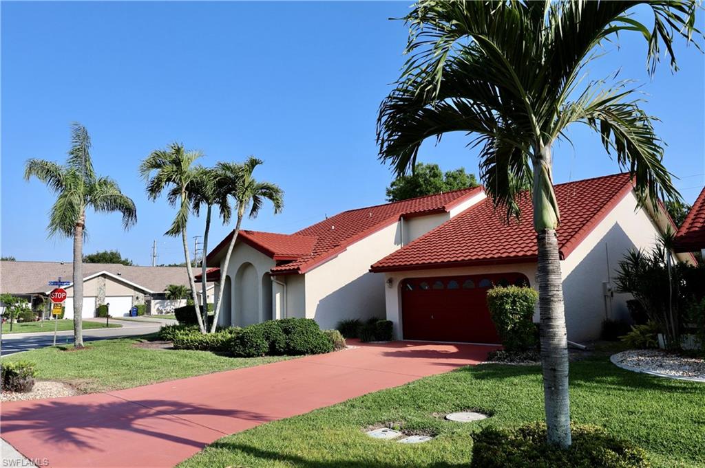 Mediterranean / spanish home with a front lawn, stucco siding, driveway, and a garage