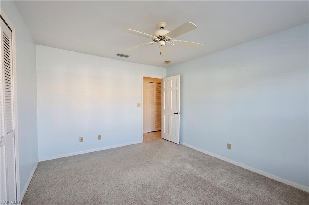 Unfurnished bedroom with light carpet, ceiling fan, and a closet
