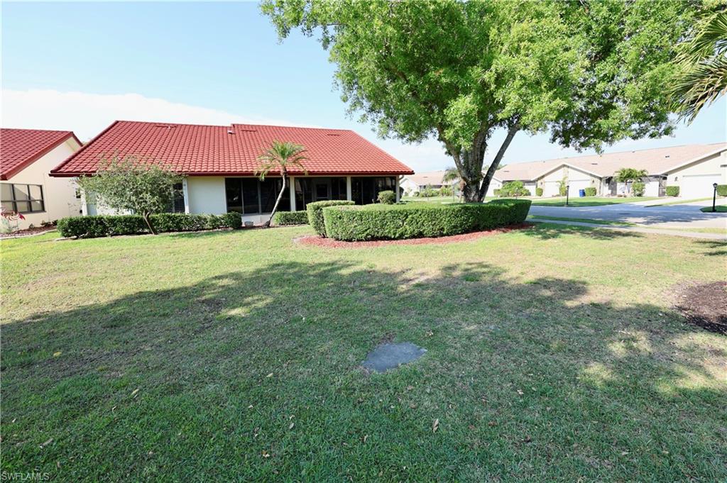 View of grassy yard featuring a sunroom and a residential view