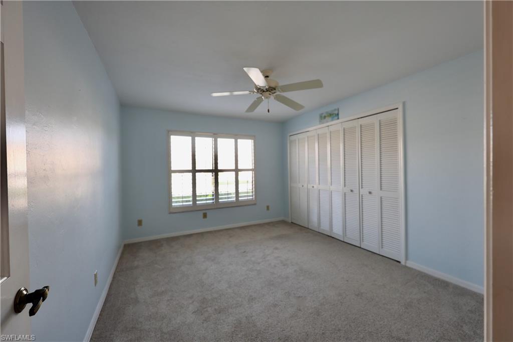 Unfurnished bedroom featuring carpet floors, a closet, and a ceiling fan