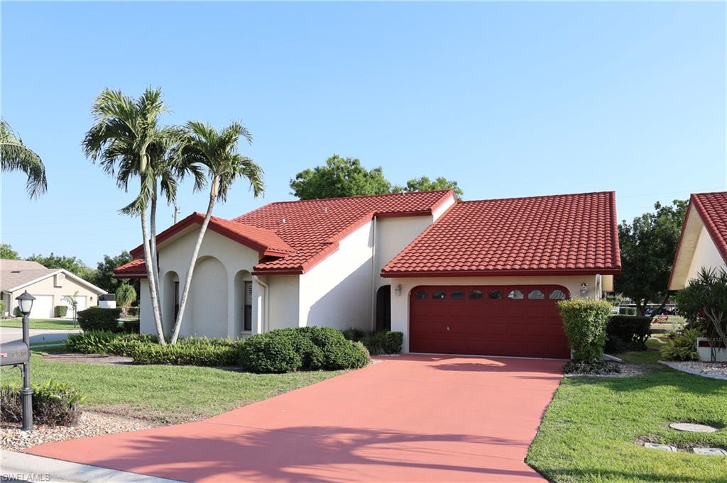 Mediterranean / spanish-style house with an attached garage, a front lawn, stucco siding, concrete driveway, and a tile roof