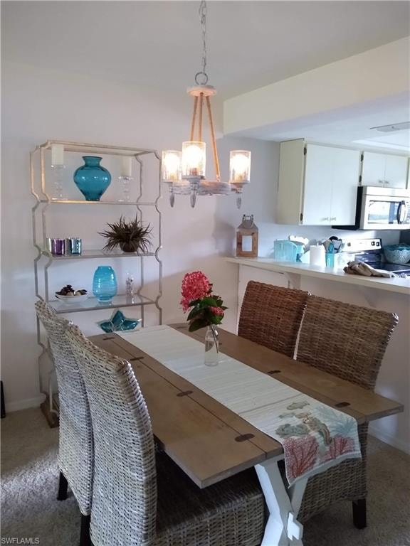 Dining area featuring light carpet and a chandelier