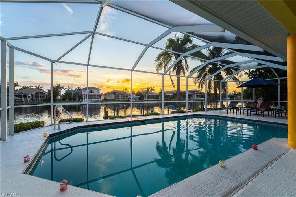 Pool at dusk with an outdoor pool and a sunroom