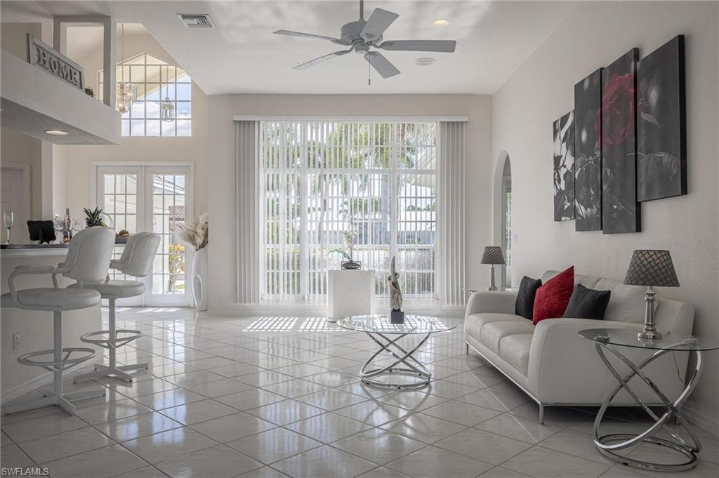 Living room with light tile patterned floors and a ceiling fan