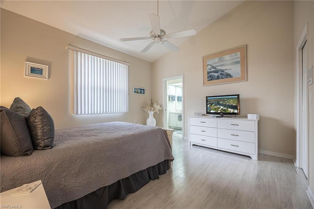 Bedroom with lofted ceiling, light wood-style flooring, multiple windows, and a ceiling fan