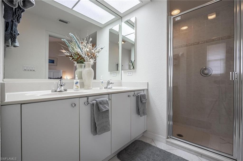 Bathroom with double vanity and a stall shower