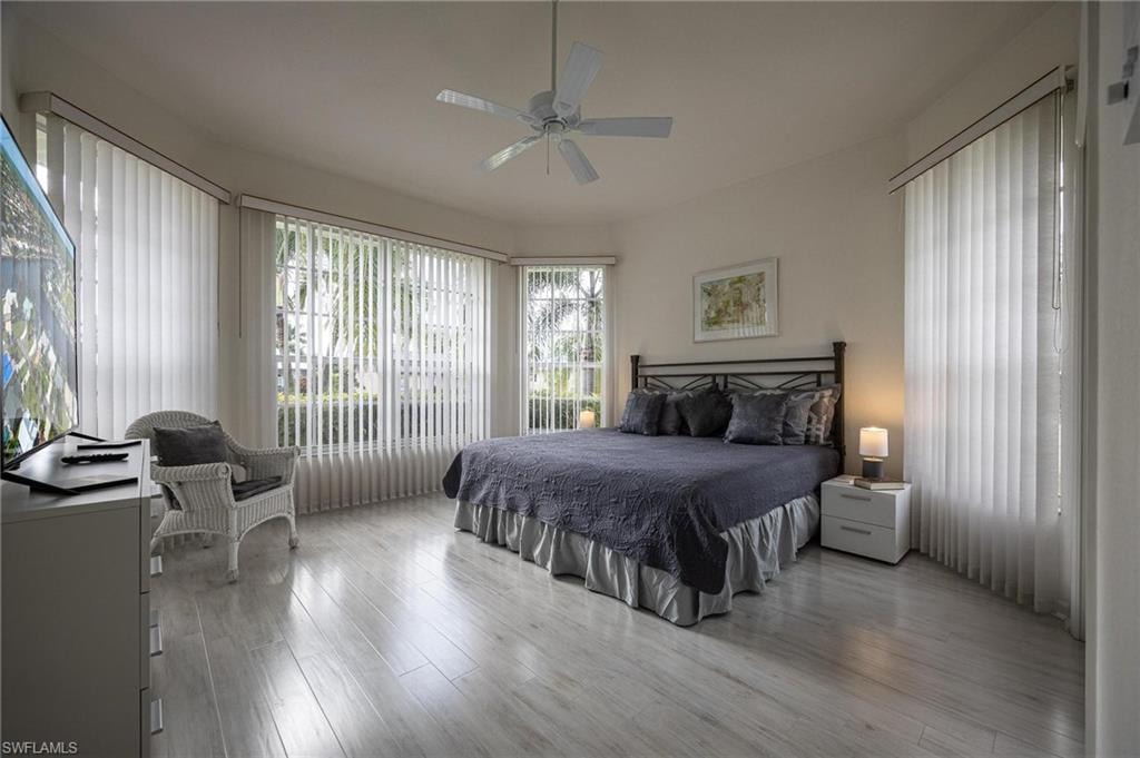 Bedroom with multiple windows, wood finished floors, and ceiling fan