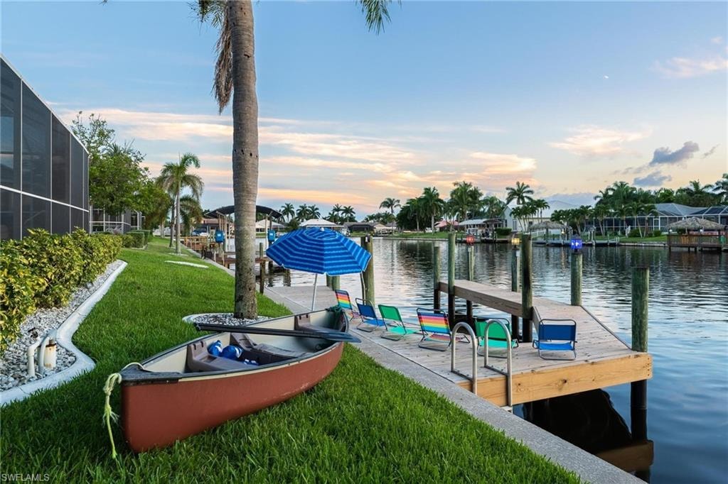 Dock with a water view and a yard