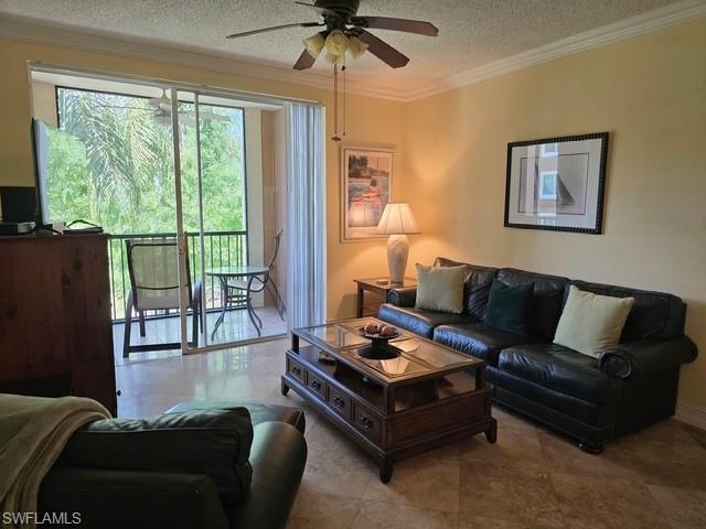 Living area featuring a textured ceiling, ornamental molding, and ceiling fan