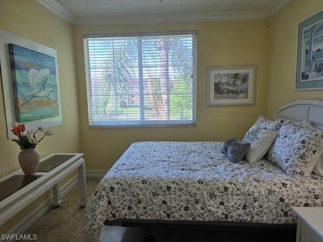 Carpeted bedroom with ornamental molding and baseboards