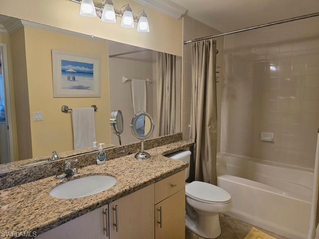 Bathroom featuring vanity, ornamental molding, shower / bathtub combination with curtain, and light tile patterned flooring