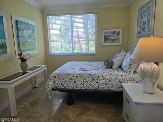 Bedroom featuring crown molding and baseboards