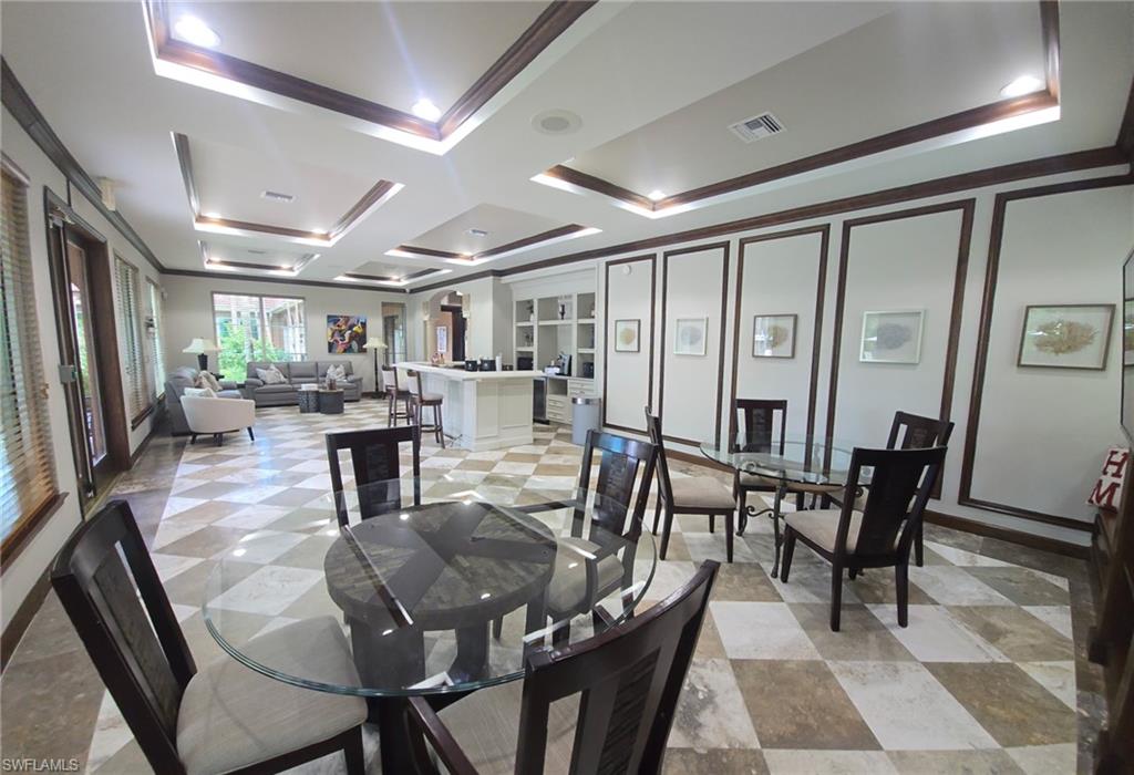 Dining room with ornamental molding, coffered ceiling, and a raised ceiling