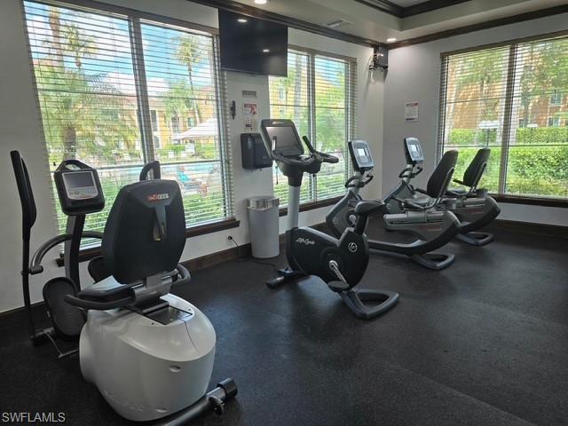 Gym with crown molding and a raised ceiling