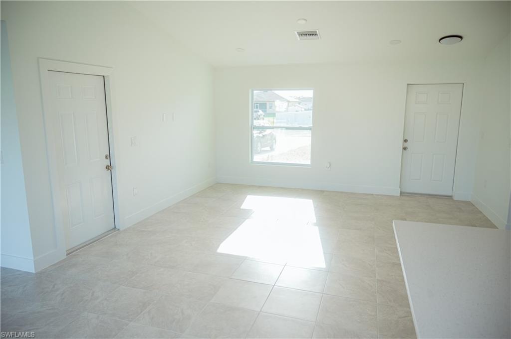 Open concept room featuring light-toned tile flooring, recessed lighting, and a neutral color palette