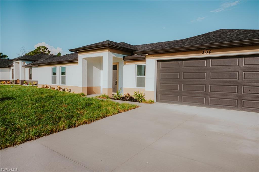 Contemporary exterior with a two-tone stucco finish, dark asphalt shingle roof, and a panel-style garage door