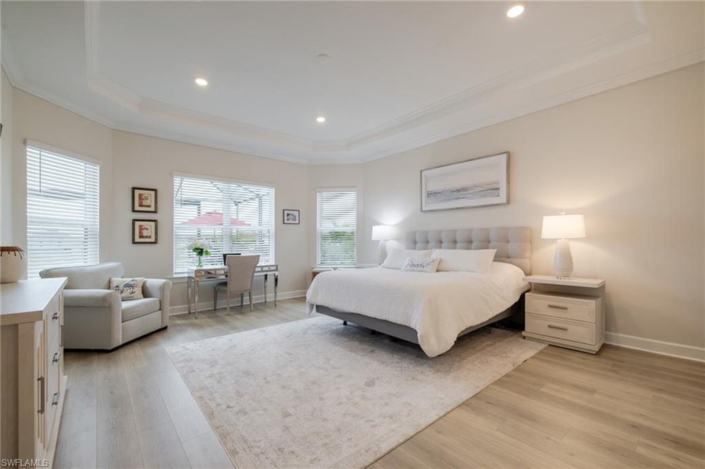 Bedroom featuring light wood finished floors, recessed lighting, crown molding, and a raised ceiling