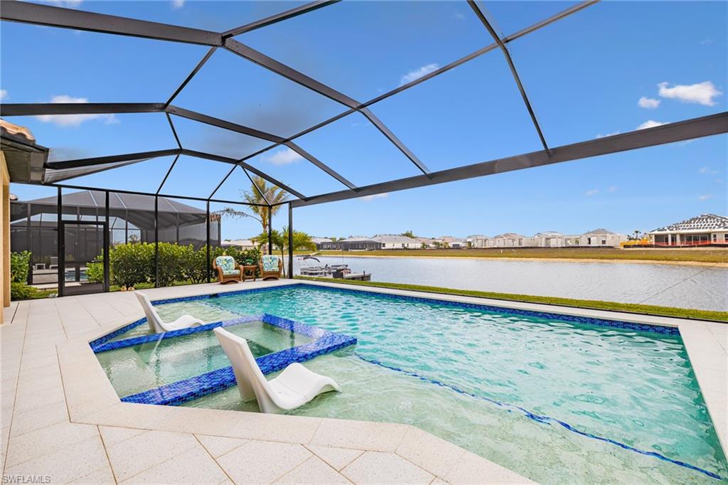 Combined pool / hot tub with a sunroom, a residential view, a lanai, a water view, and a patio