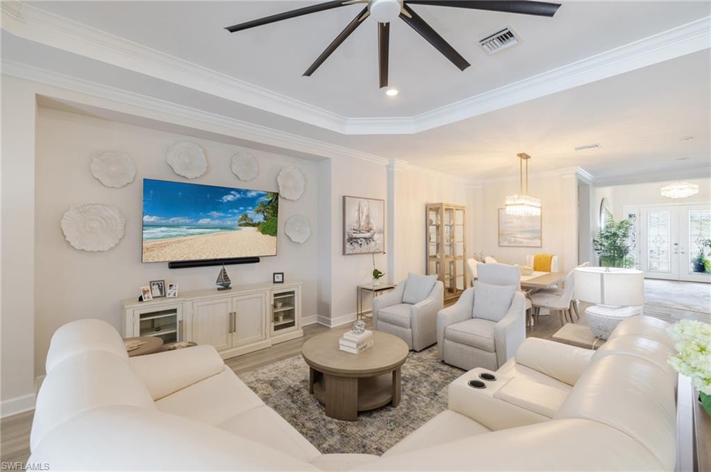 Living area featuring a ceiling fan, light wood finished floors, recessed lighting, ornamental molding, and french doors