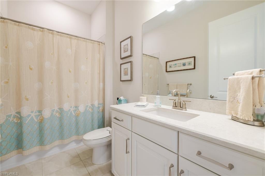 Bathroom with vanity, light tile patterned floors, and shower / bath combination with curtain