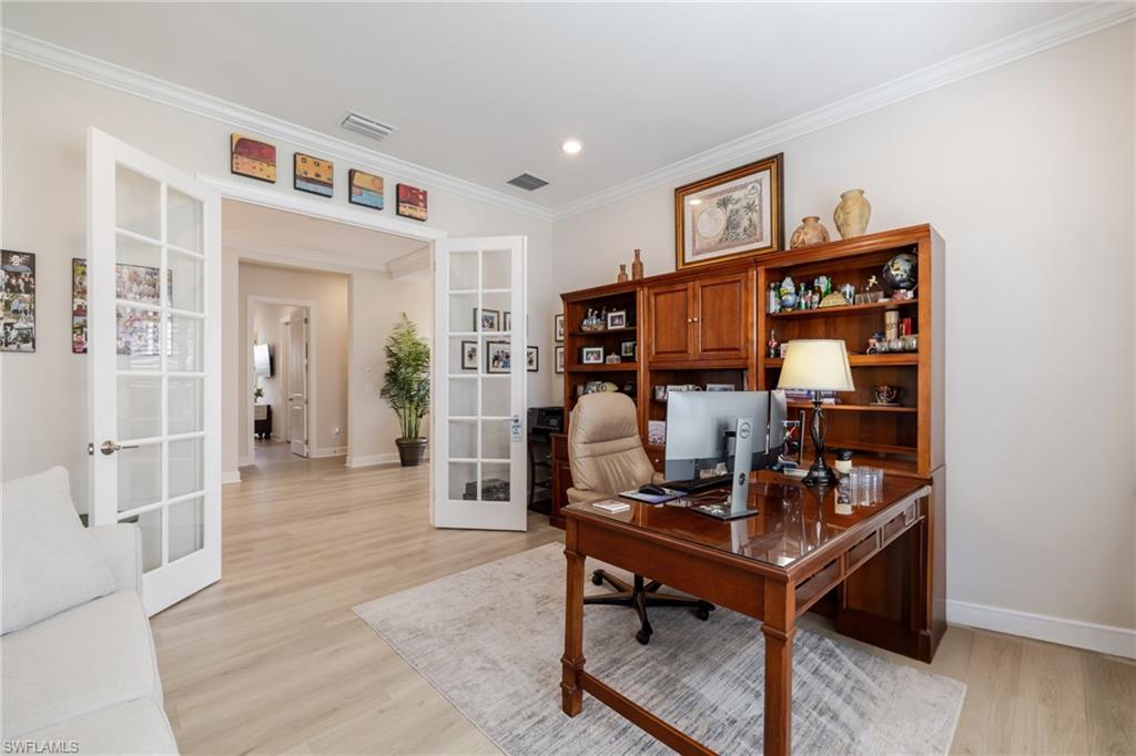 Office with french doors, light wood finished floors, and crown molding