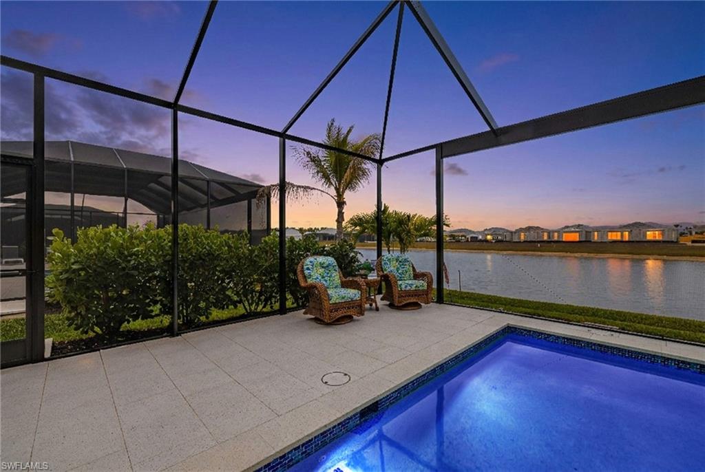 Swimming pool with a lanai, a sunroom, and a water view