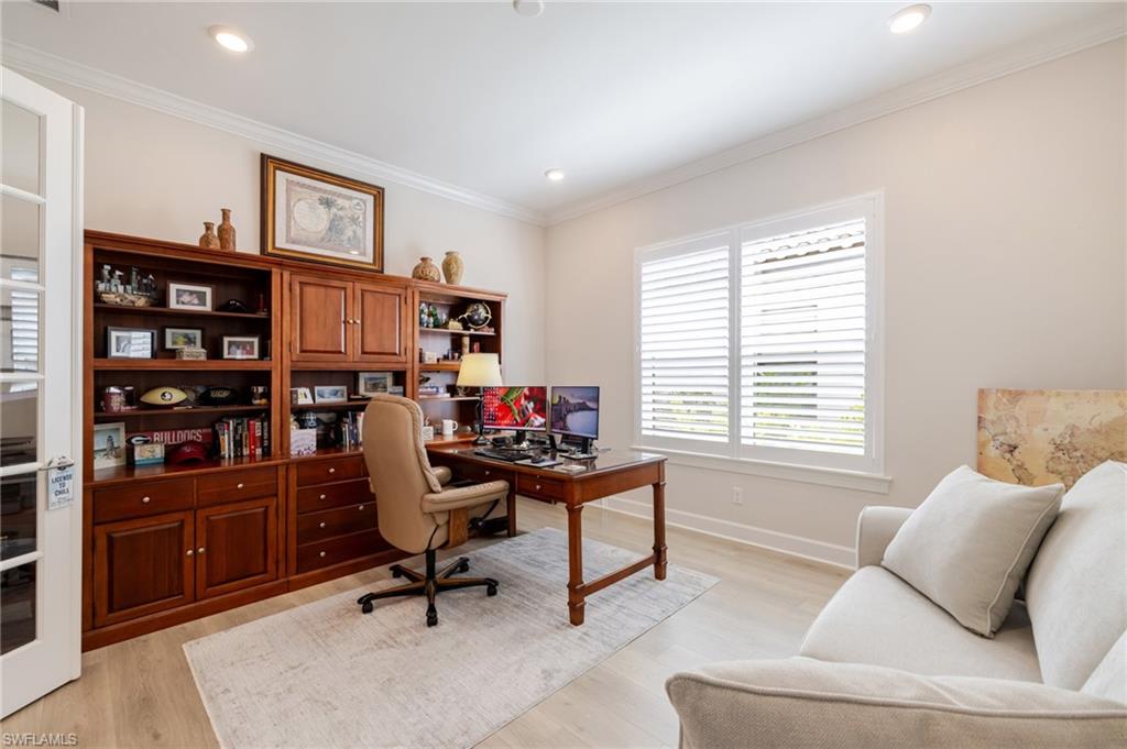 Office with light wood finished floors, crown molding, and recessed lighting