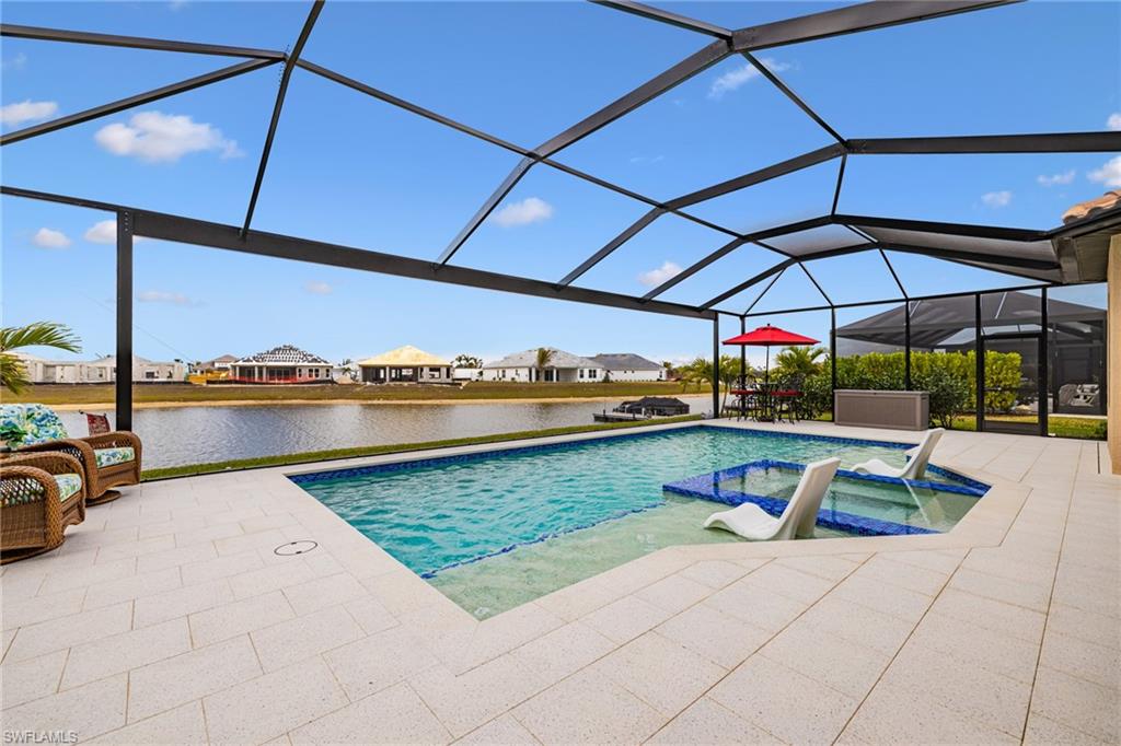 Integrated pool / hot tub featuring a sunroom, a residential view, a lanai, a patio area, and a water view