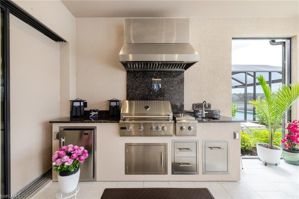 View of patio with an outdoor kitchen and a lanai