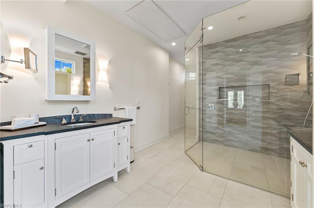 Full bathroom with vanity, visible vents, recessed lighting, a stall shower, and baseboards
