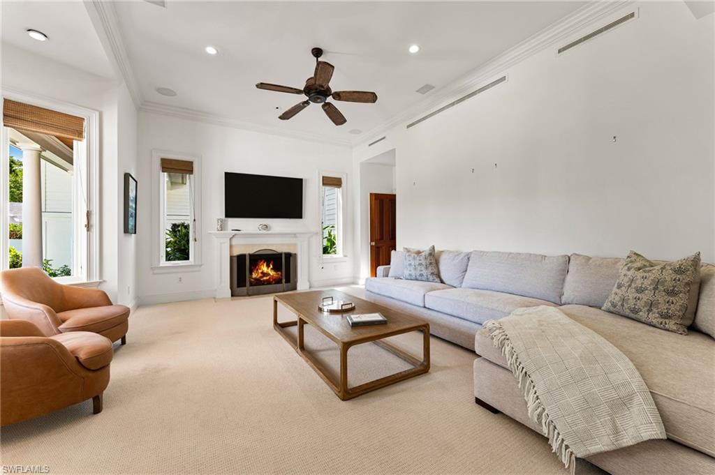 Living room featuring crown molding, a healthy amount of sunlight, and visible vents