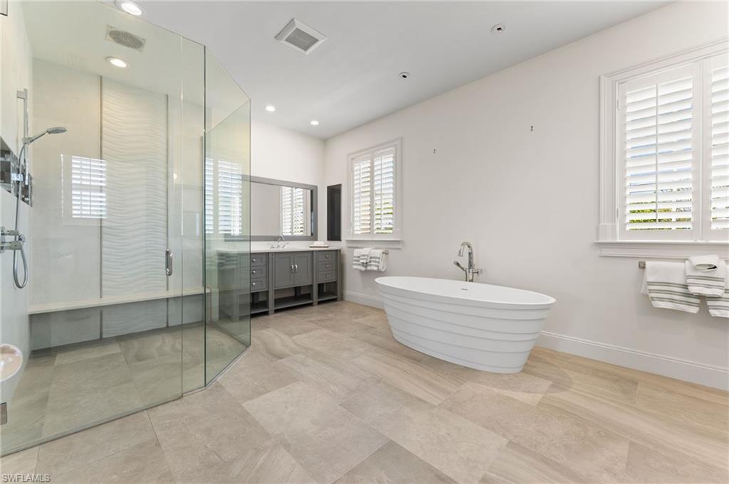 Full bath with vanity, a stall shower, a soaking tub, recessed lighting, and visible vents