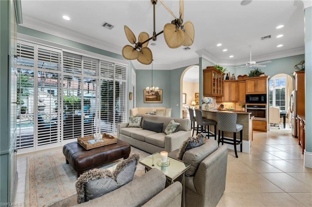 High ceilings, generous crown moldings, and neutral tile flooring...