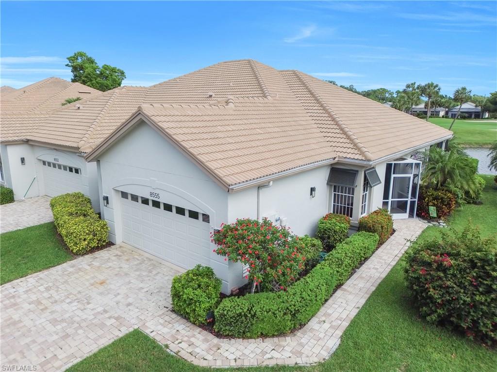 Ranch-style home with an attached garage, a tiled roof, stucco siding, decorative driveway, and a sunroom