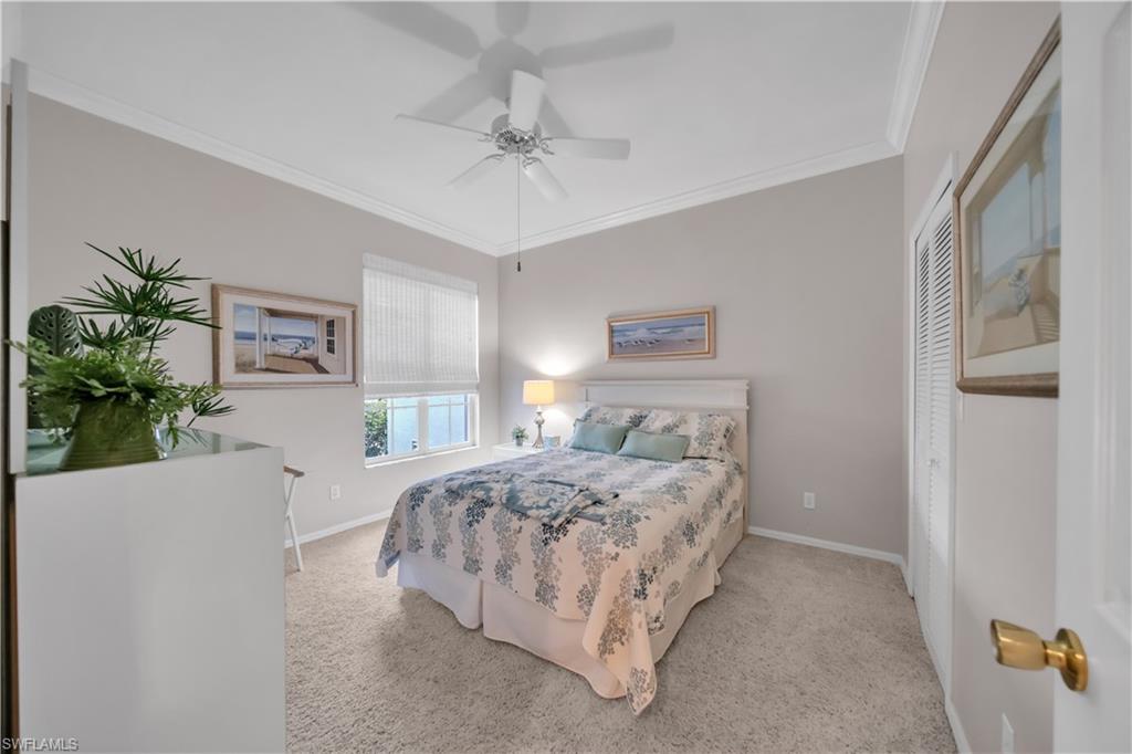 Bedroom with ornamental molding, light colored carpet, a ceiling fan, and a closet