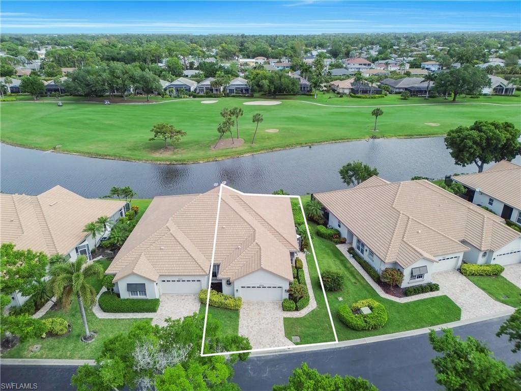 Aerial perspective of suburban area with a golf course and a nearby body of water