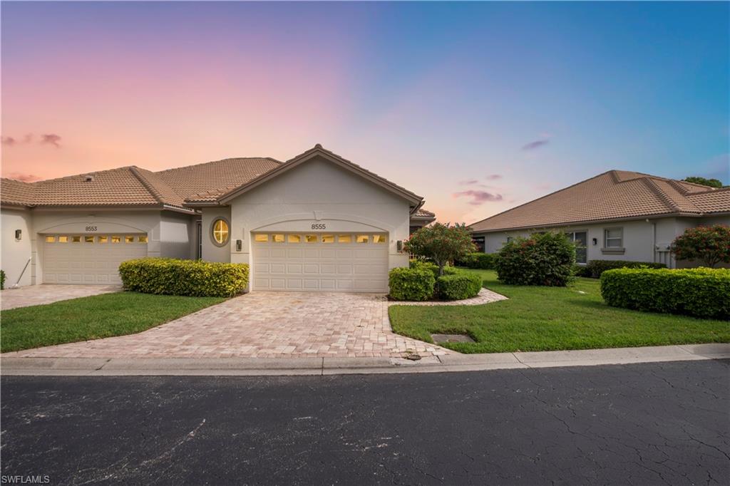 View of front of property featuring stucco siding, a front lawn, an attached garage, decorative driveway, and a tile roof