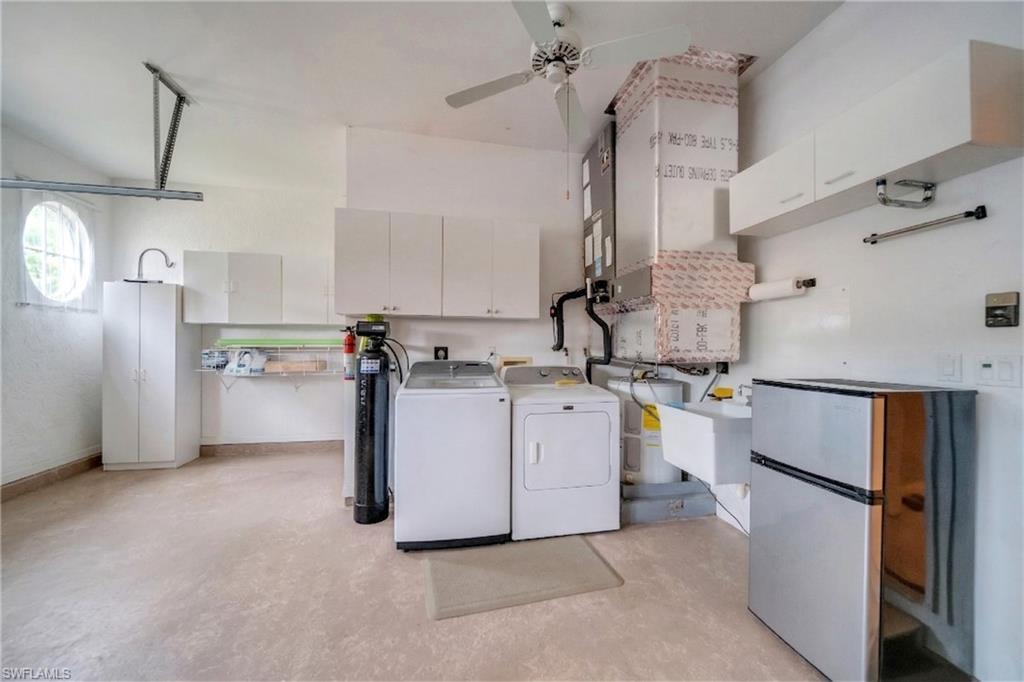 Laundry area featuring ceiling fan, washer and dryer, and light flooring