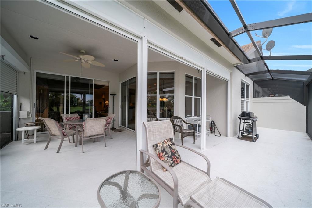 View of patio / terrace with outdoor dining space, a sunroom, a ceiling fan, grilling area, and a lanai