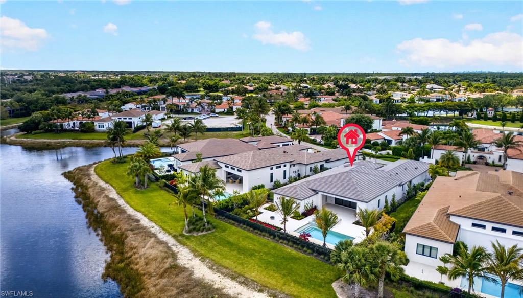 Aerial view of residential area with a pool and a large body of water