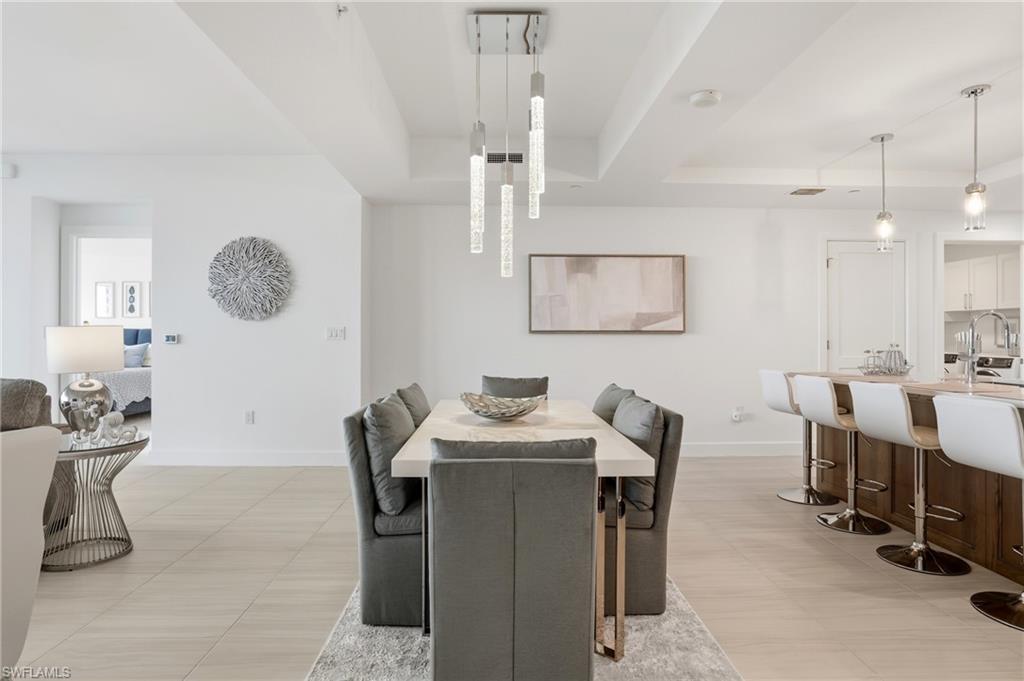 Dining space with a tray ceiling and elegant chandeliers  - Virtually Edited Image