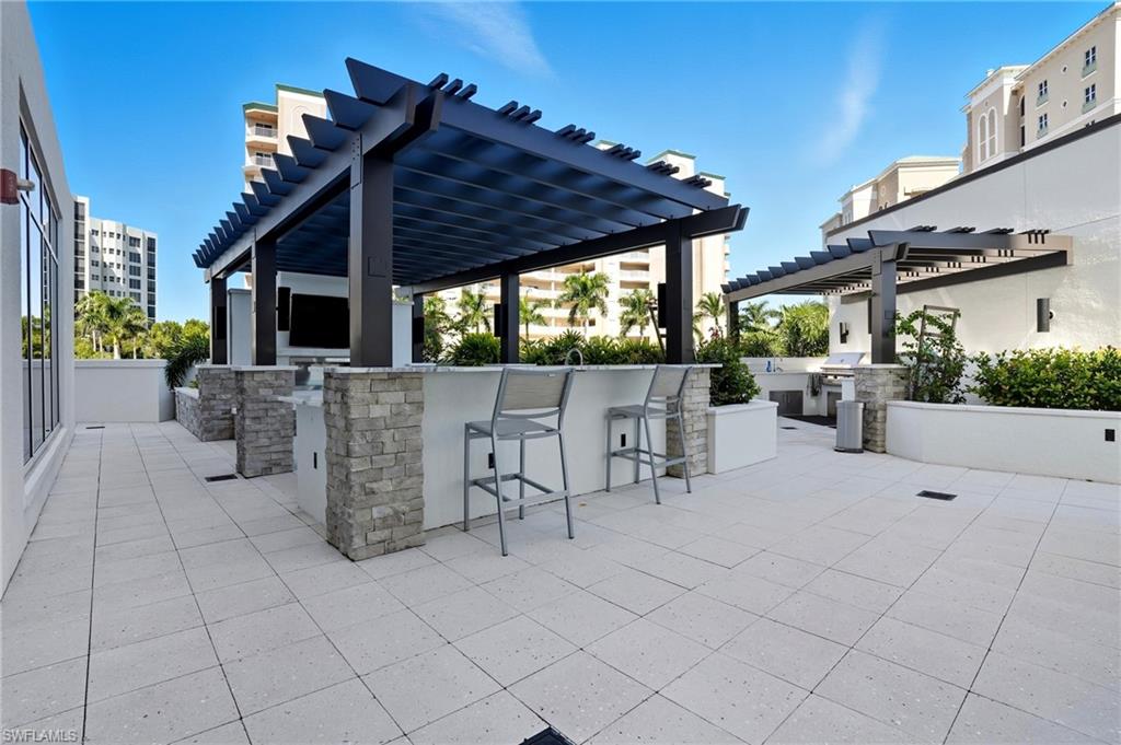 View of outdoor patio with a pergola and exterior kitchen- Virtually Edited